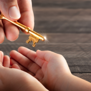 Adult handing a golden key to a child with open hands
