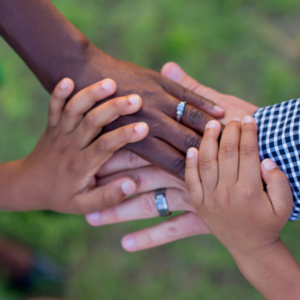 Several hands on top of each other of different ethnic origin
